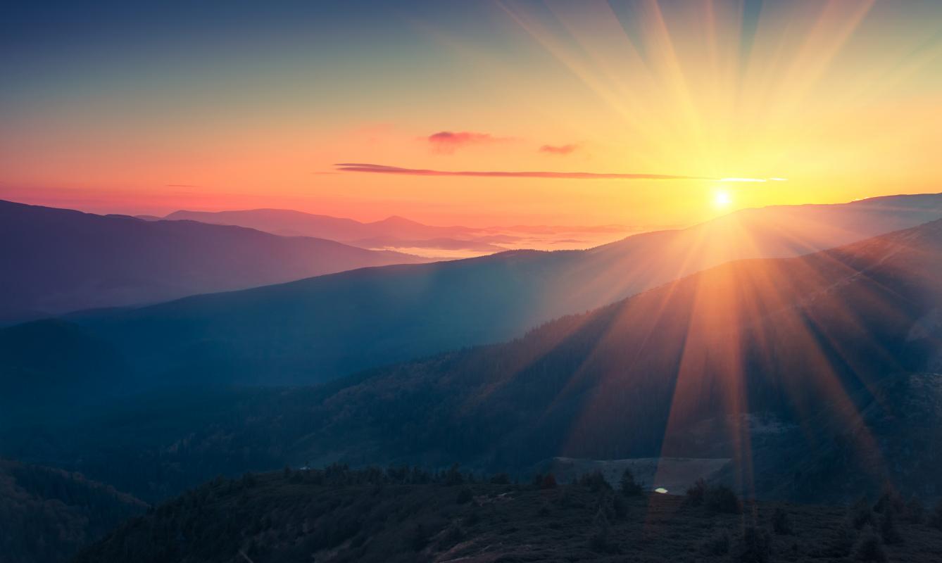 Stock photo of sunrise seen over mountains