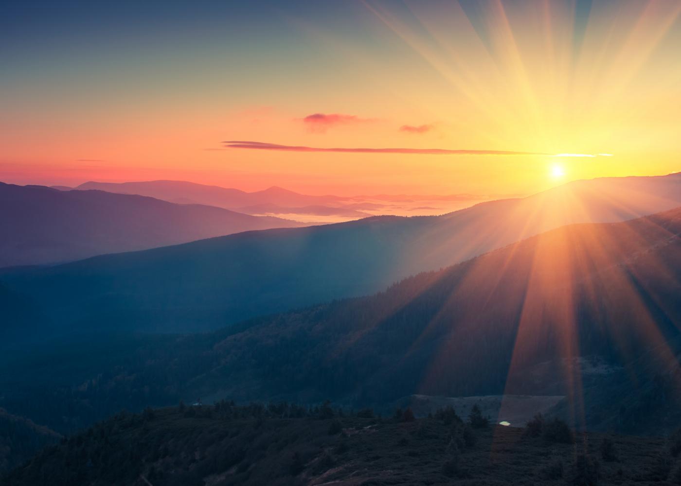 Stock photo of sunrise seen over mountains