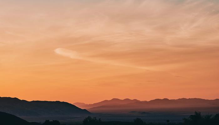 View down empty California road across the desert at sunset