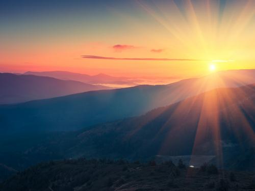 Stock photo of sunrise seen over mountains